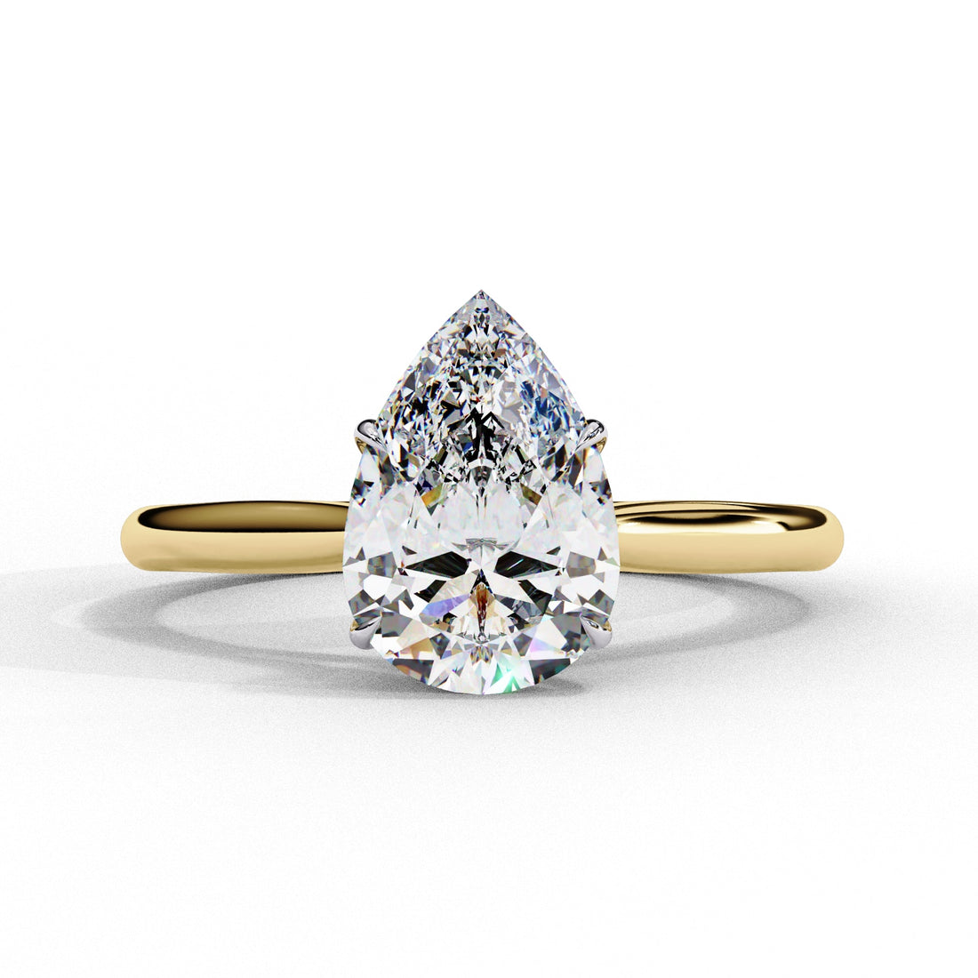 Gold ring with a pear-shaped diamond on a white background