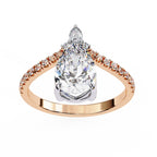 Rose gold ring with a large pear-shaped diamond and smaller diamonds on the band against a white background