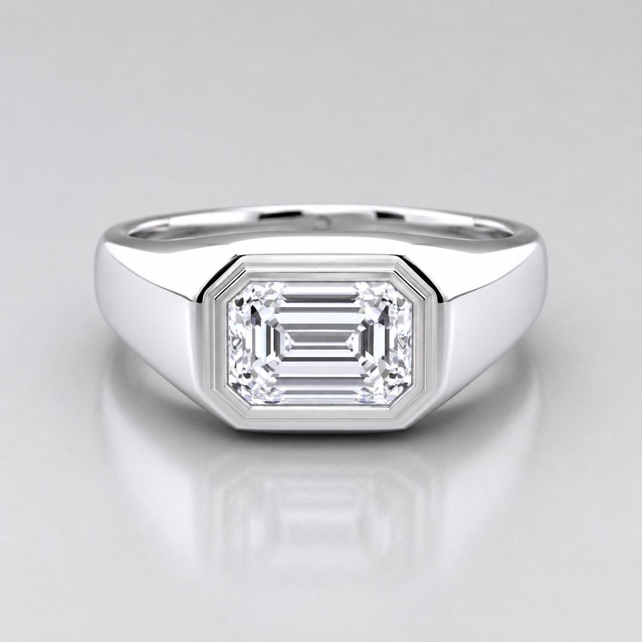 1.50 ct emerald cut lab grown diamond engagement ring with a polished bezel setting and wide band for men.