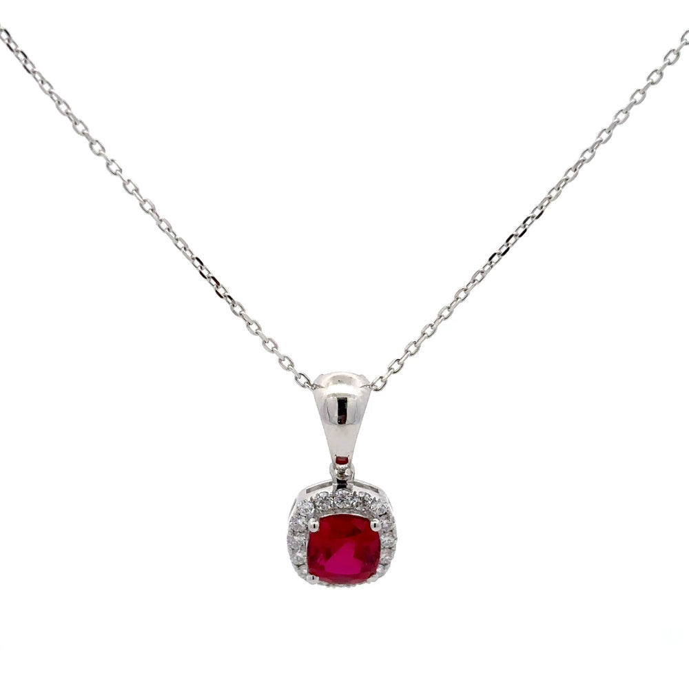 Silver necklace with a red gemstone pendant on a white background
