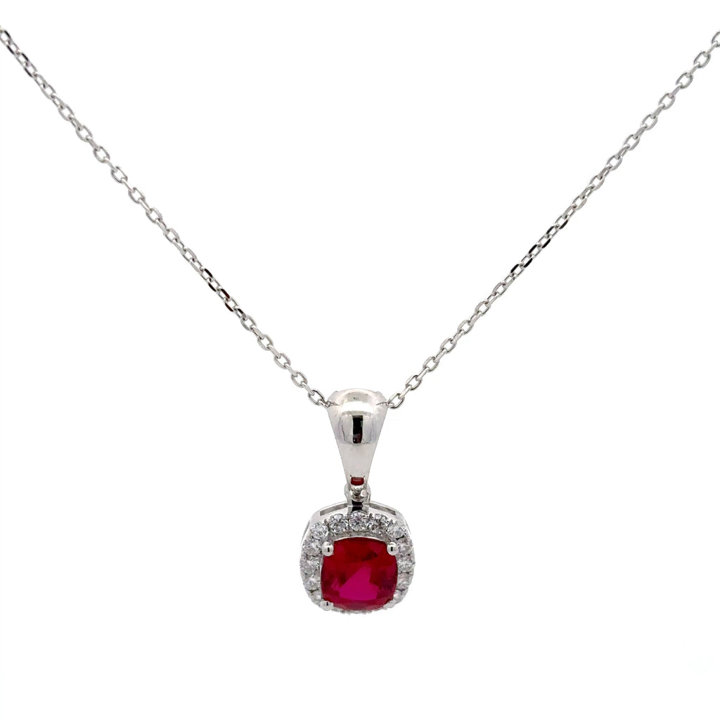 Silver necklace with a red gemstone pendant on a white background