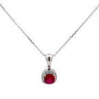 Silver necklace with a red gemstone pendant on a white background