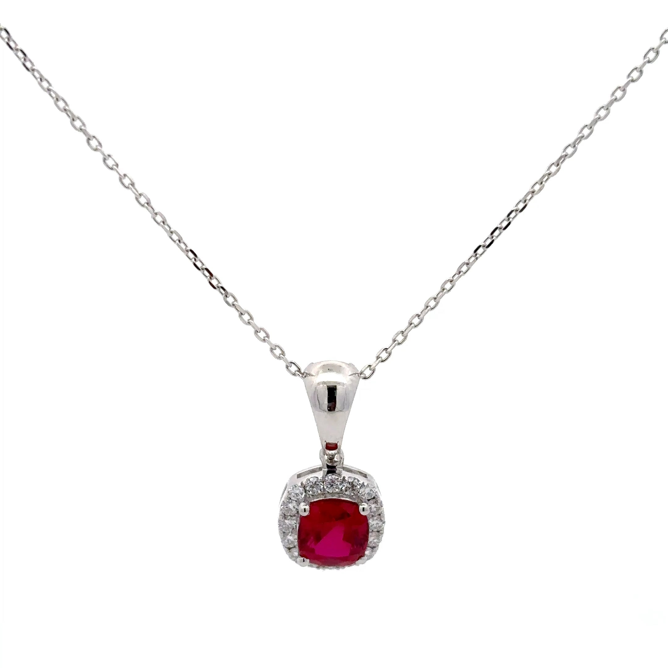 Silver necklace with a red gemstone pendant on a white background
