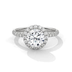 Round cut diamond halo engagement ring in white gold with a pavé diamond band, shown in a front product view.