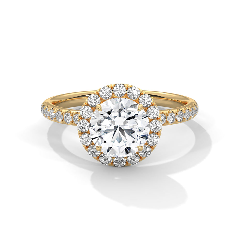 Round cut diamond halo engagement ring in yellow gold with a pavé diamond band, shown in a front product view.