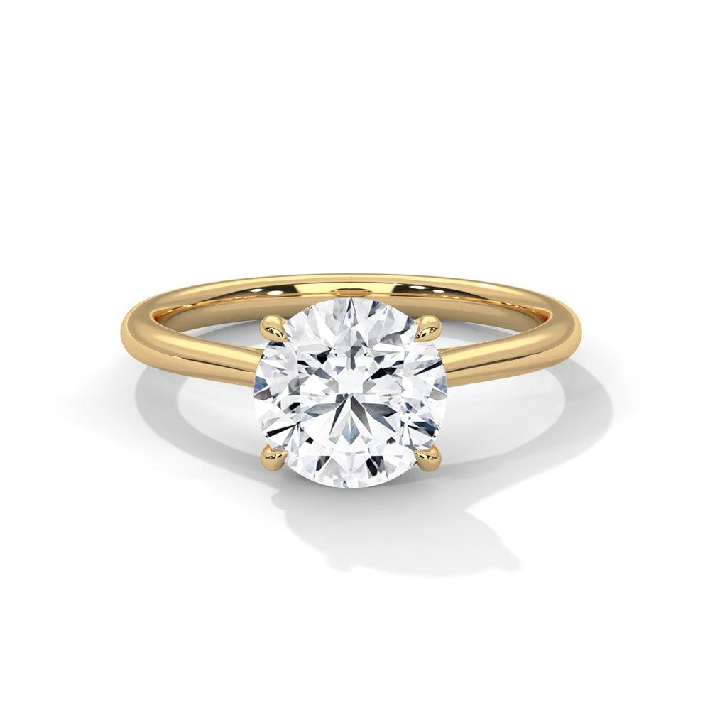 Round cut diamond solitaire engagement ring in yellow gold with a four-prong setting and plain band, shown in a front product view.