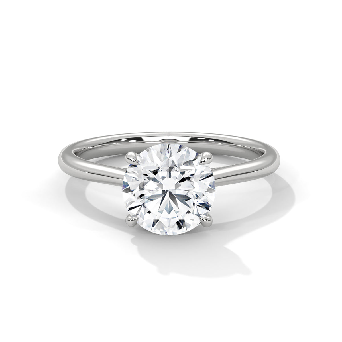Round cut diamond solitaire engagement ring in white gold with a four-prong setting and plain band, shown in a front product view.