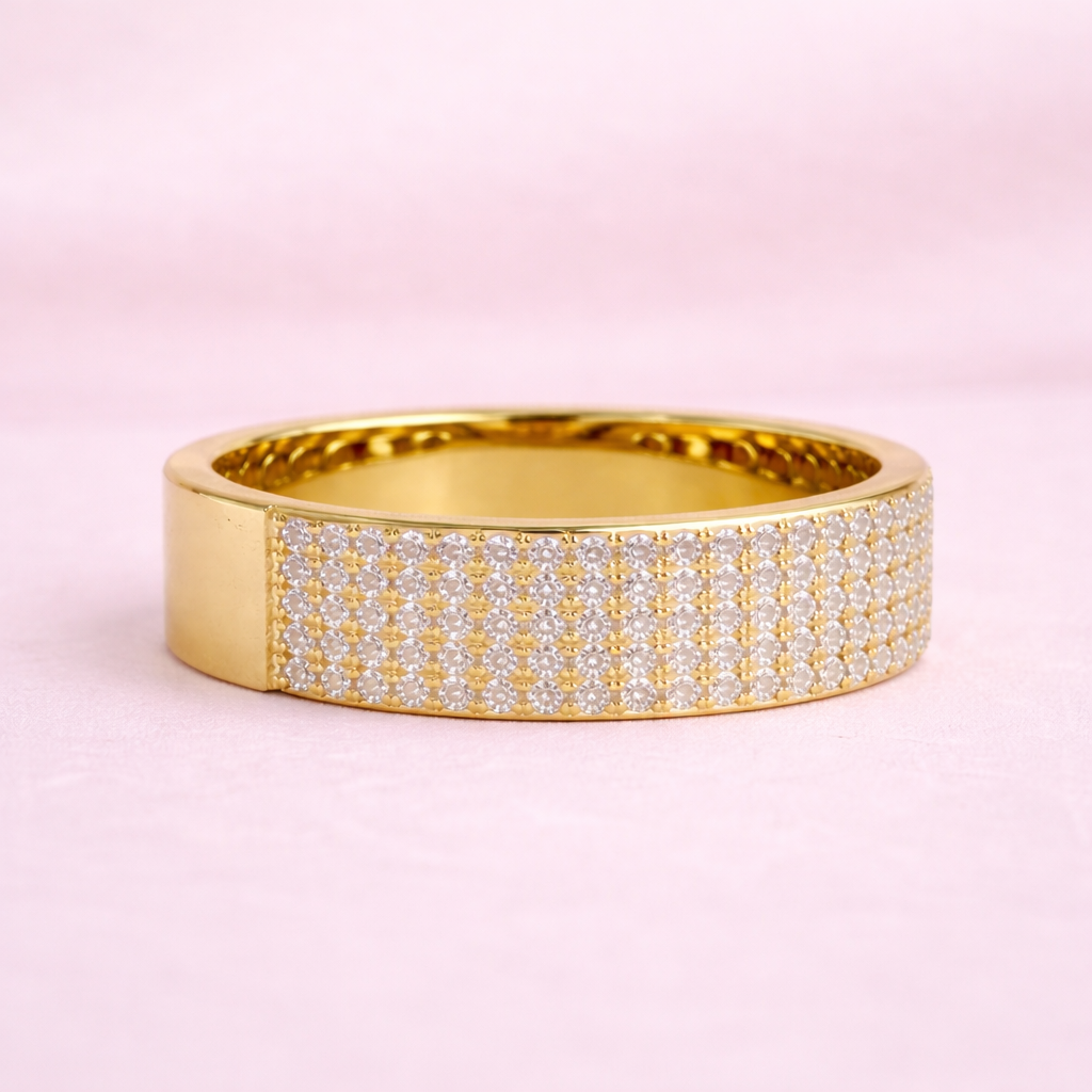 Gold ring with diamond accents on a pink background