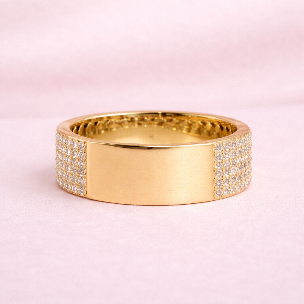 Gold ring with diamond accents on a pink background