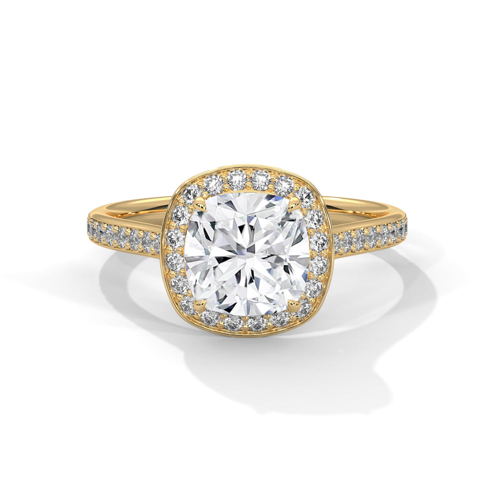 Cushion cut diamond halo engagement ring in yellow gold with a pave diamond band, shown in a front product view.
