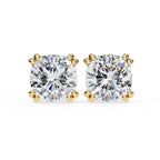 Pair of diamond stud earrings with gold prongs on a white background