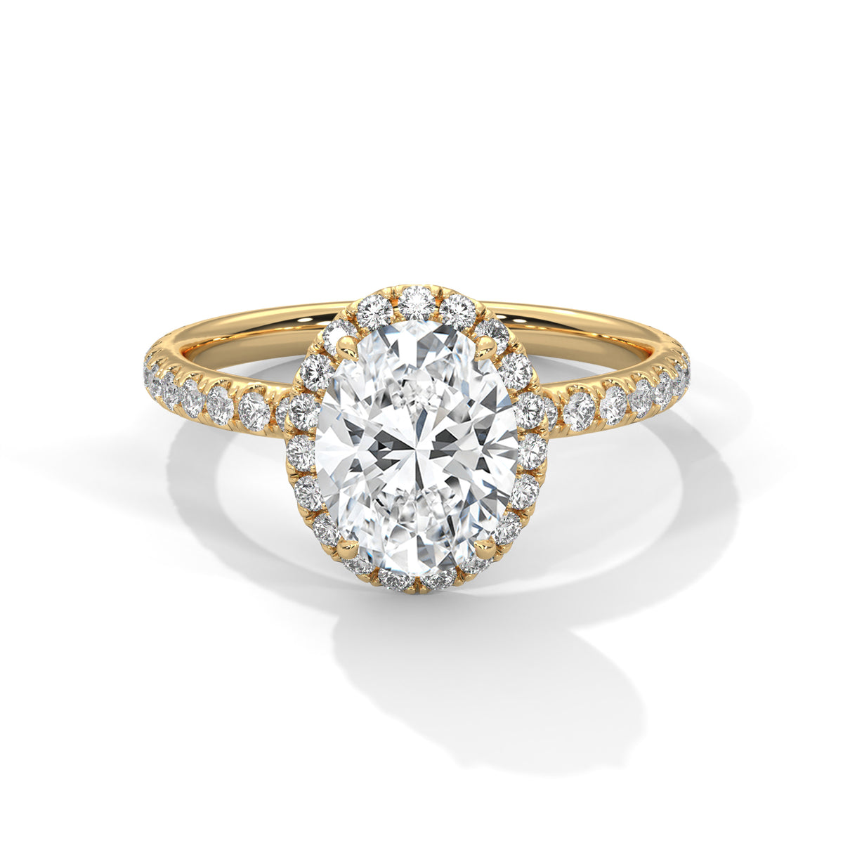 Oval cut diamond halo engagement ring in yellow gold with a pavé diamond band, shown in a front product view.