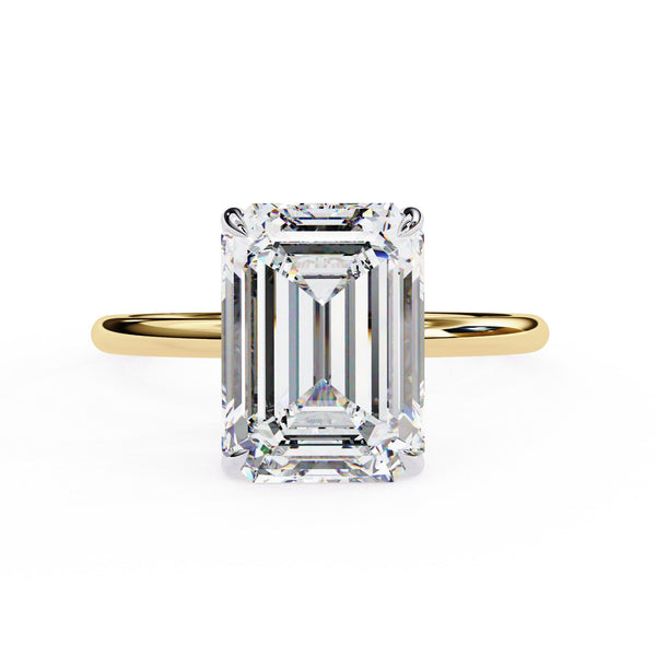 Gold ring with a large emerald-cut diamond on a white background