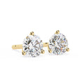 Gold earrings with clear gemstones on a white background