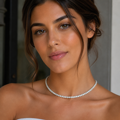 Woman wearing a silver necklace with a neutral background