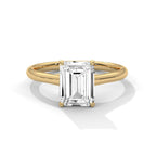 Gold ring with a rectangular diamond on a white background