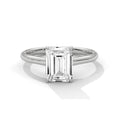 Diamond ring with emerald-cut gemstone on a white background