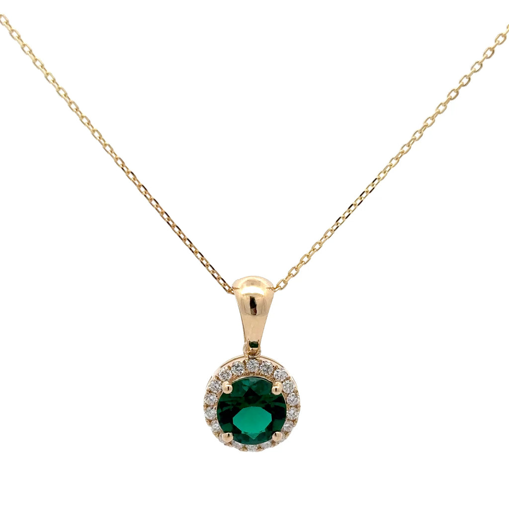 Gold necklace with a green gemstone pendant on a white background