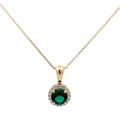 Gold necklace with a green gemstone pendant on a white background