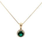 Gold necklace with a green gemstone pendant on a white background