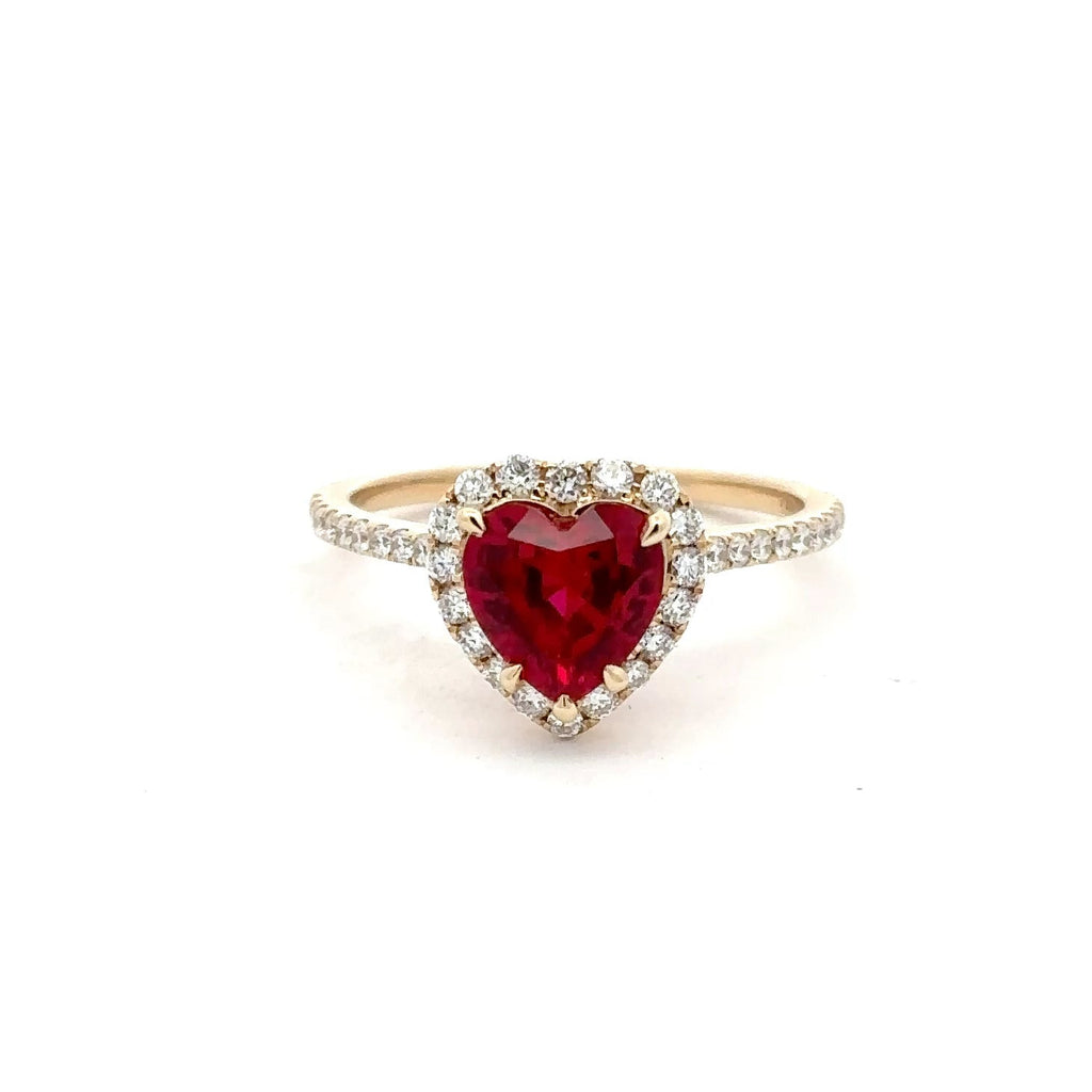 Ring with a heart-shaped red gemstone on a white background