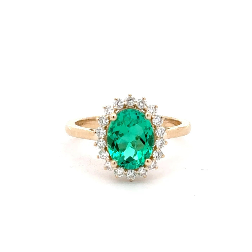 Gold ring with a green gemstone on a white background