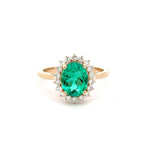 Gold ring with a green gemstone on a white background