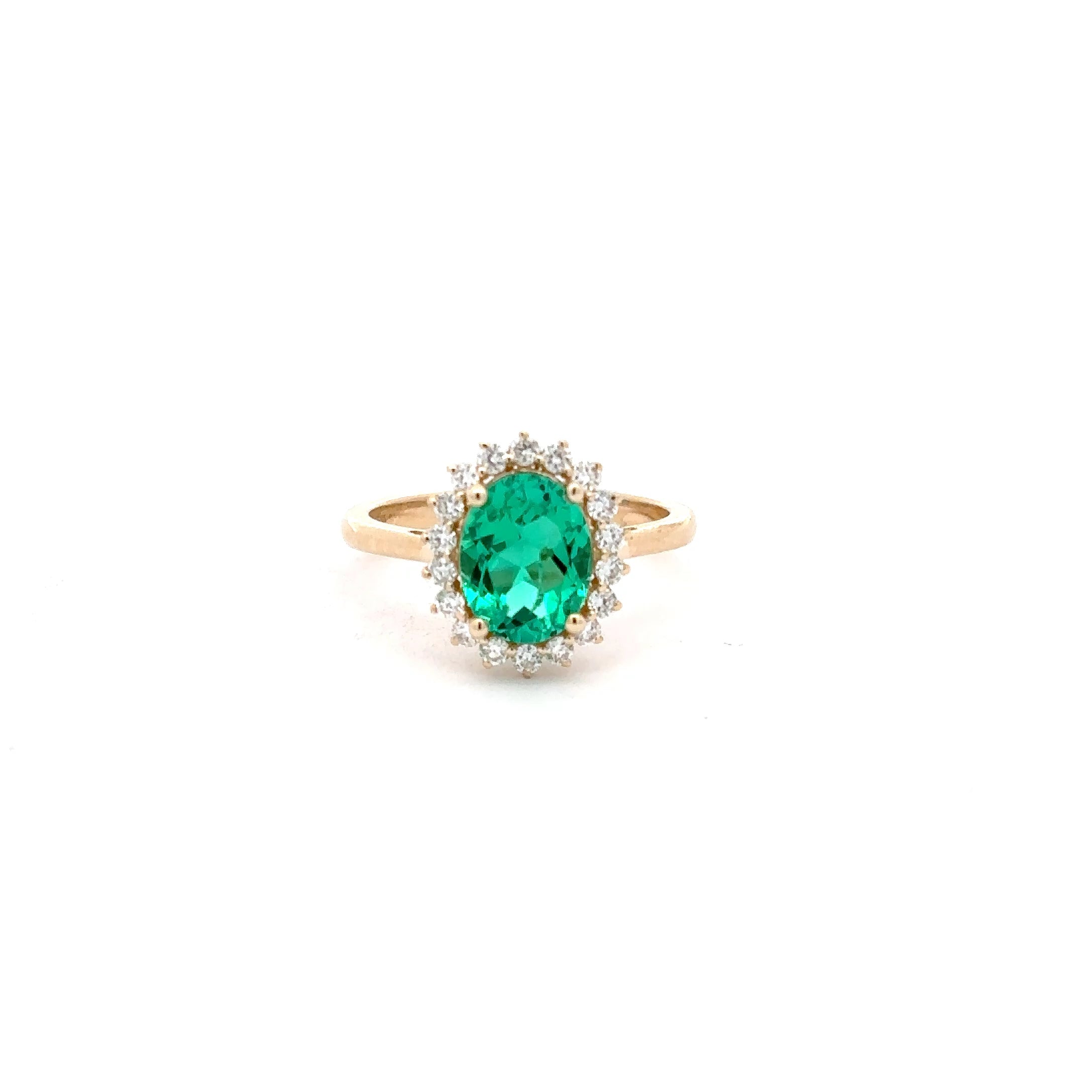 Gold ring with a green gemstone on a white background