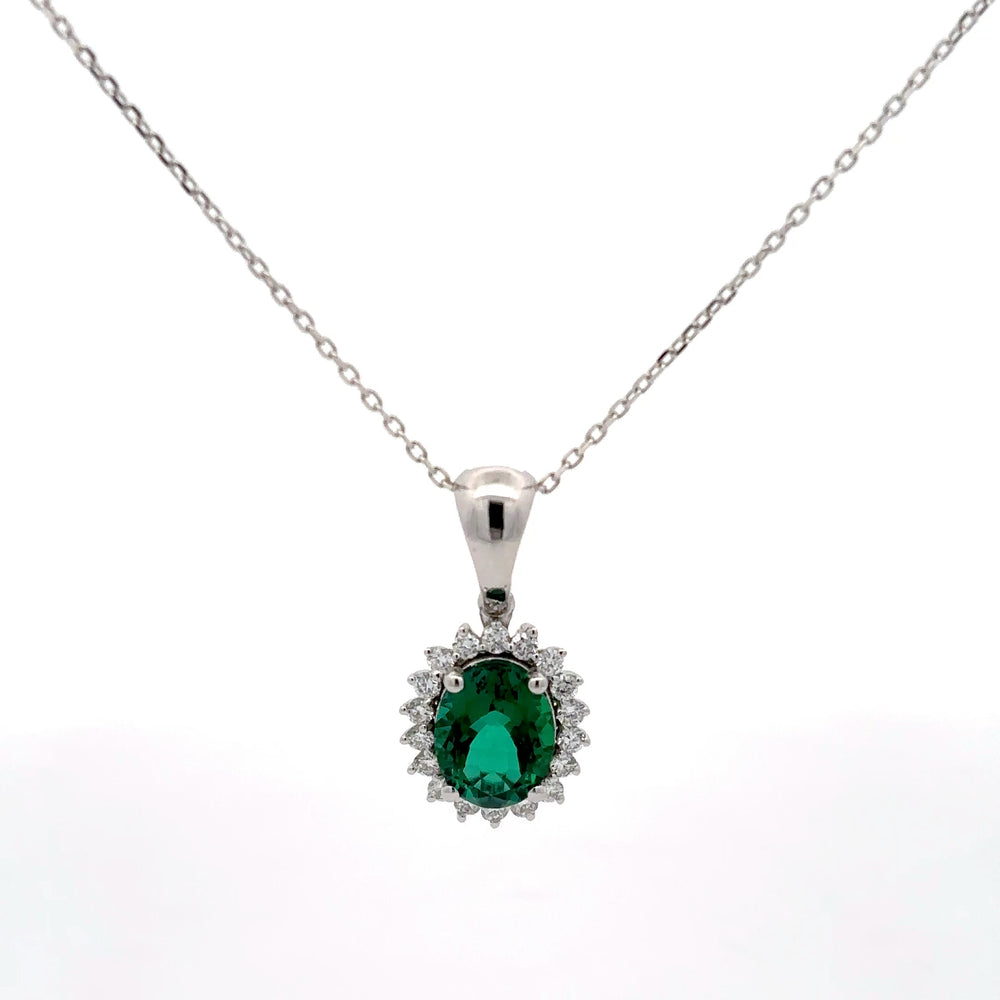 Silver pendant with a green gemstone on a white background