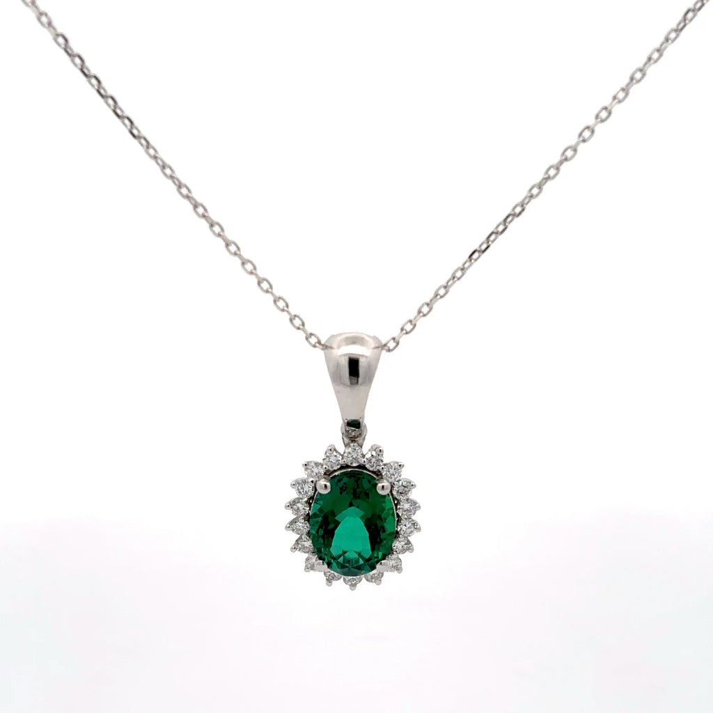 Silver pendant with a green gemstone on a white background