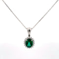 Silver pendant with a green gemstone on a white background