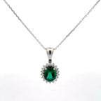 Silver pendant with a green gemstone on a white background
