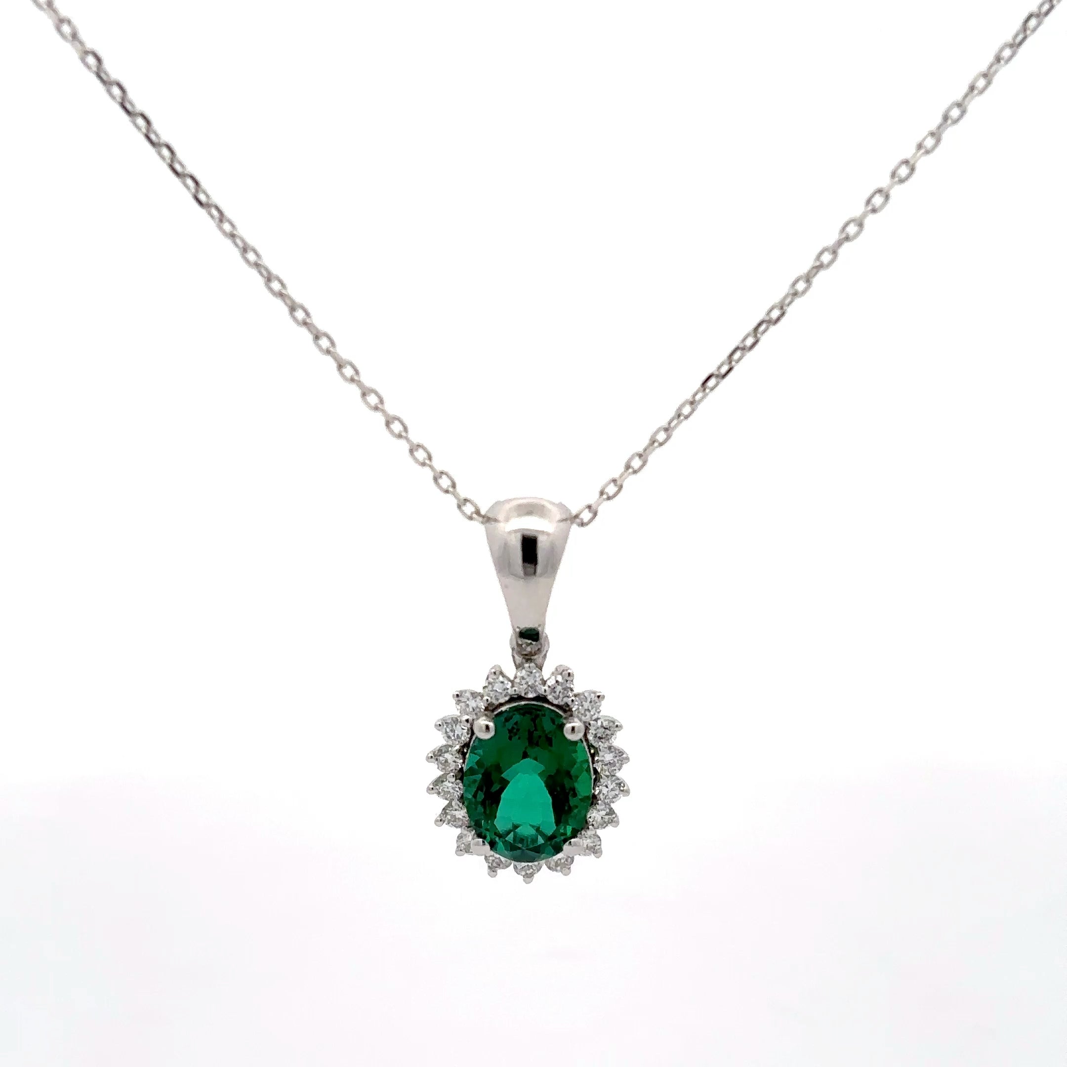 Silver pendant with a green gemstone on a white background