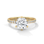 Gold ring with a large diamond and smaller diamonds on the band against a white background