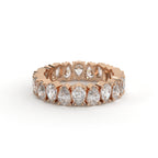 Rose gold ring with pear-shaped diamonds on a white background