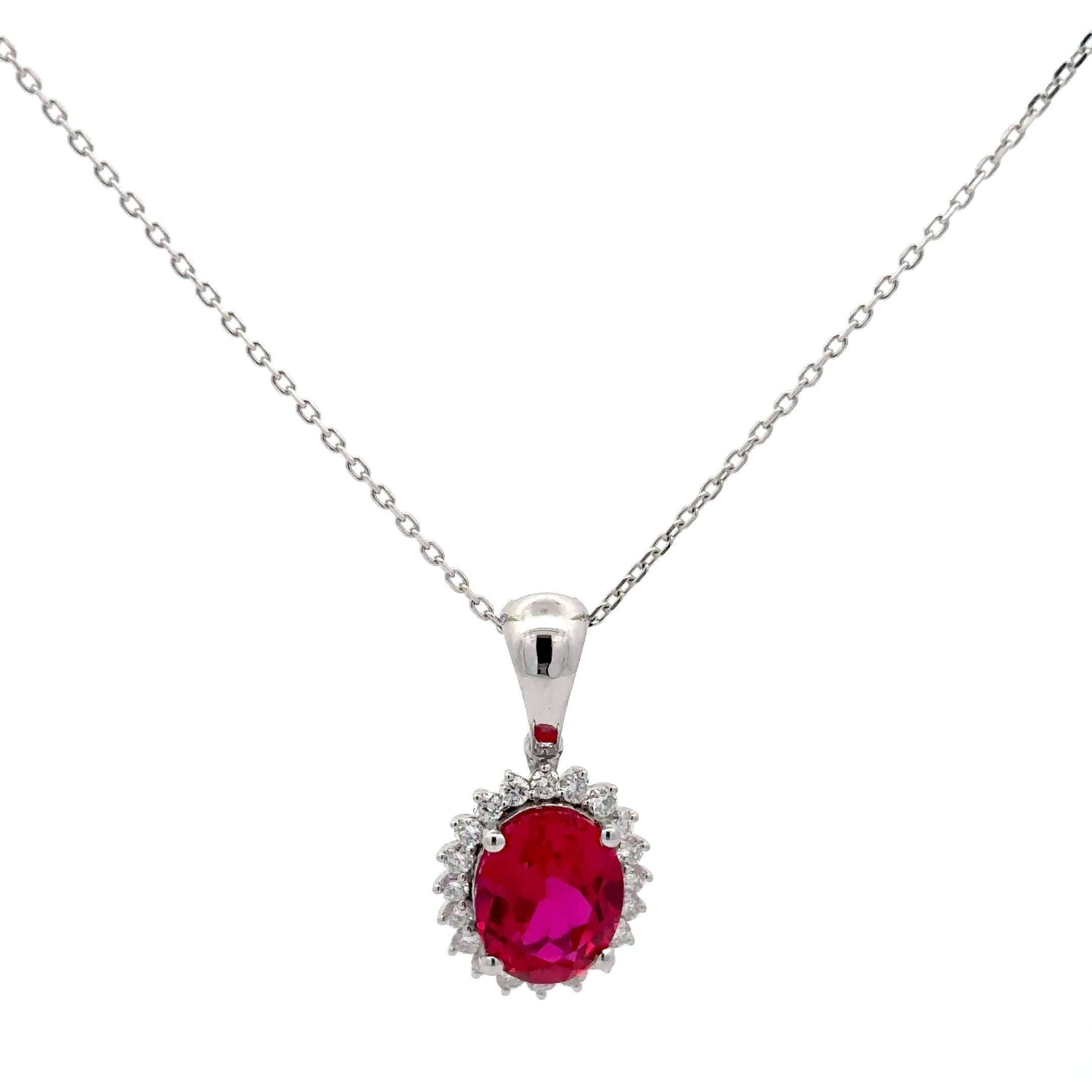 Silver necklace with a red gemstone pendant on a white background