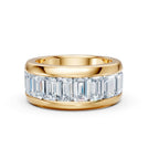 Gold ring with emerald-cut diamonds on a white background