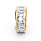 Gold ring with emerald-cut diamonds on a white background