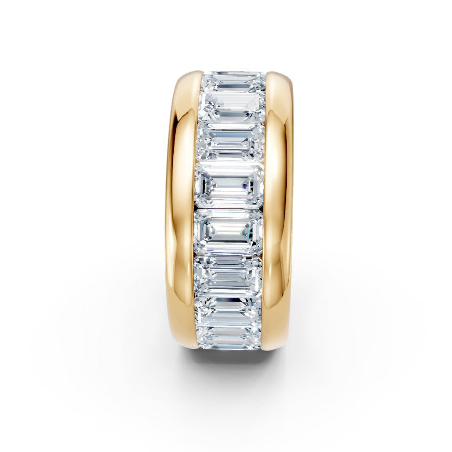 Gold ring with emerald-cut diamonds on a white background