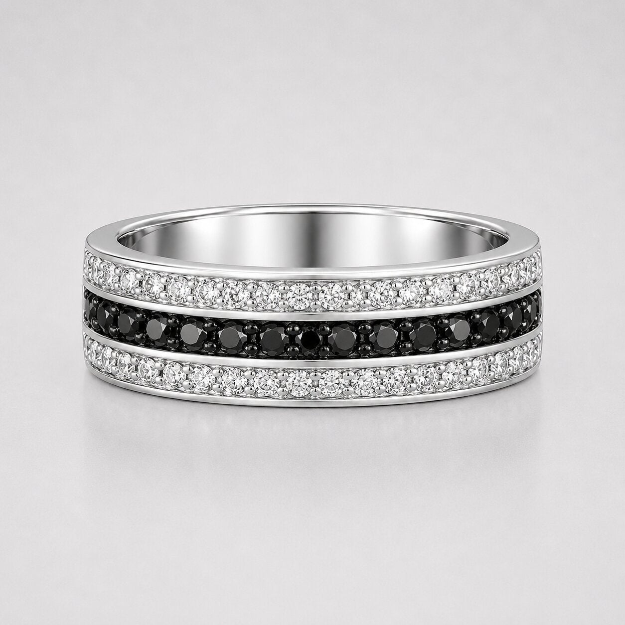 Channel set round black and white diamond men's wedding band featuring a center row of black diamonds framed by white diamond rows in a polished white gold band.
