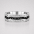 Silver ring with black and white gemstones on a light gray background