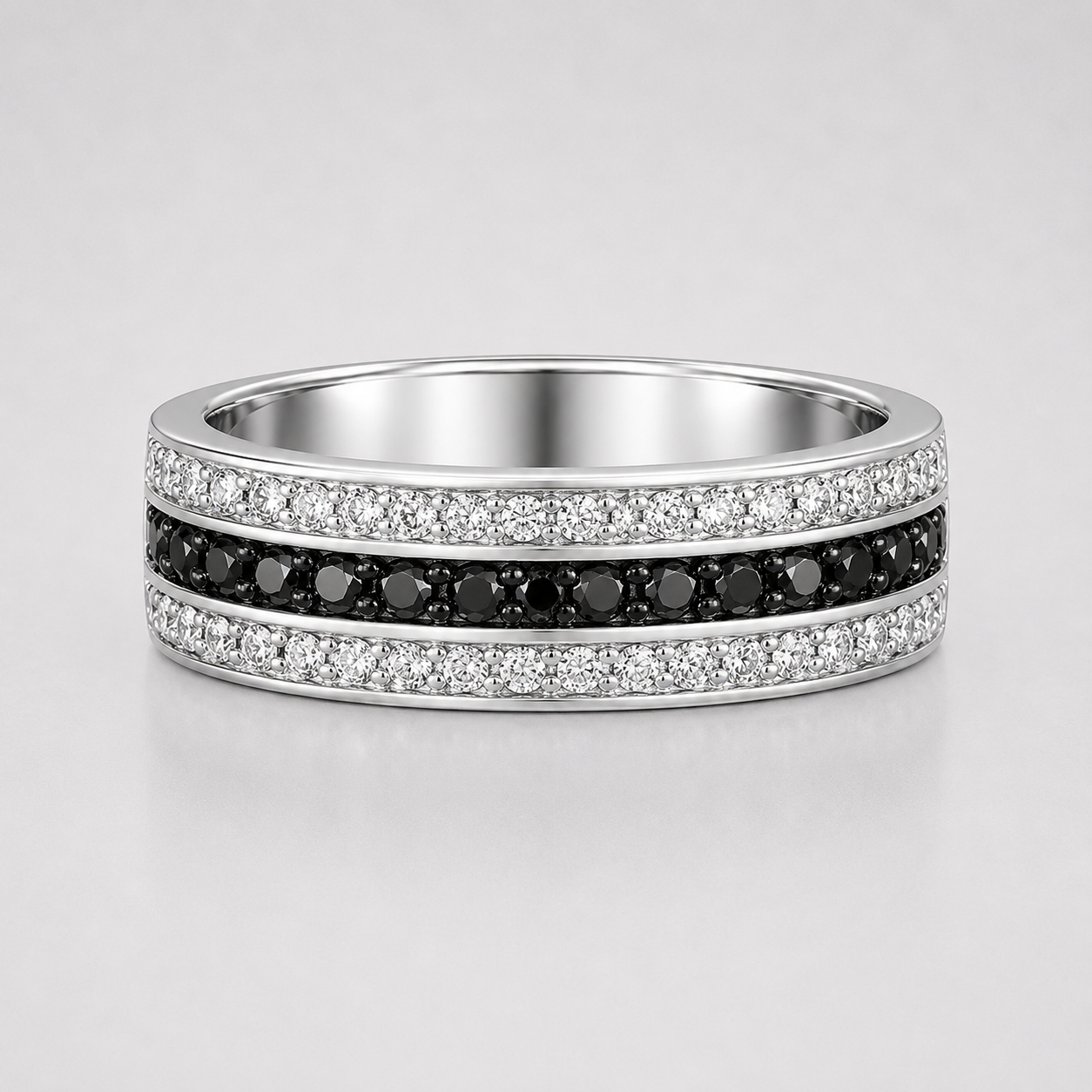 Silver ring with black and white gemstones on a light gray background