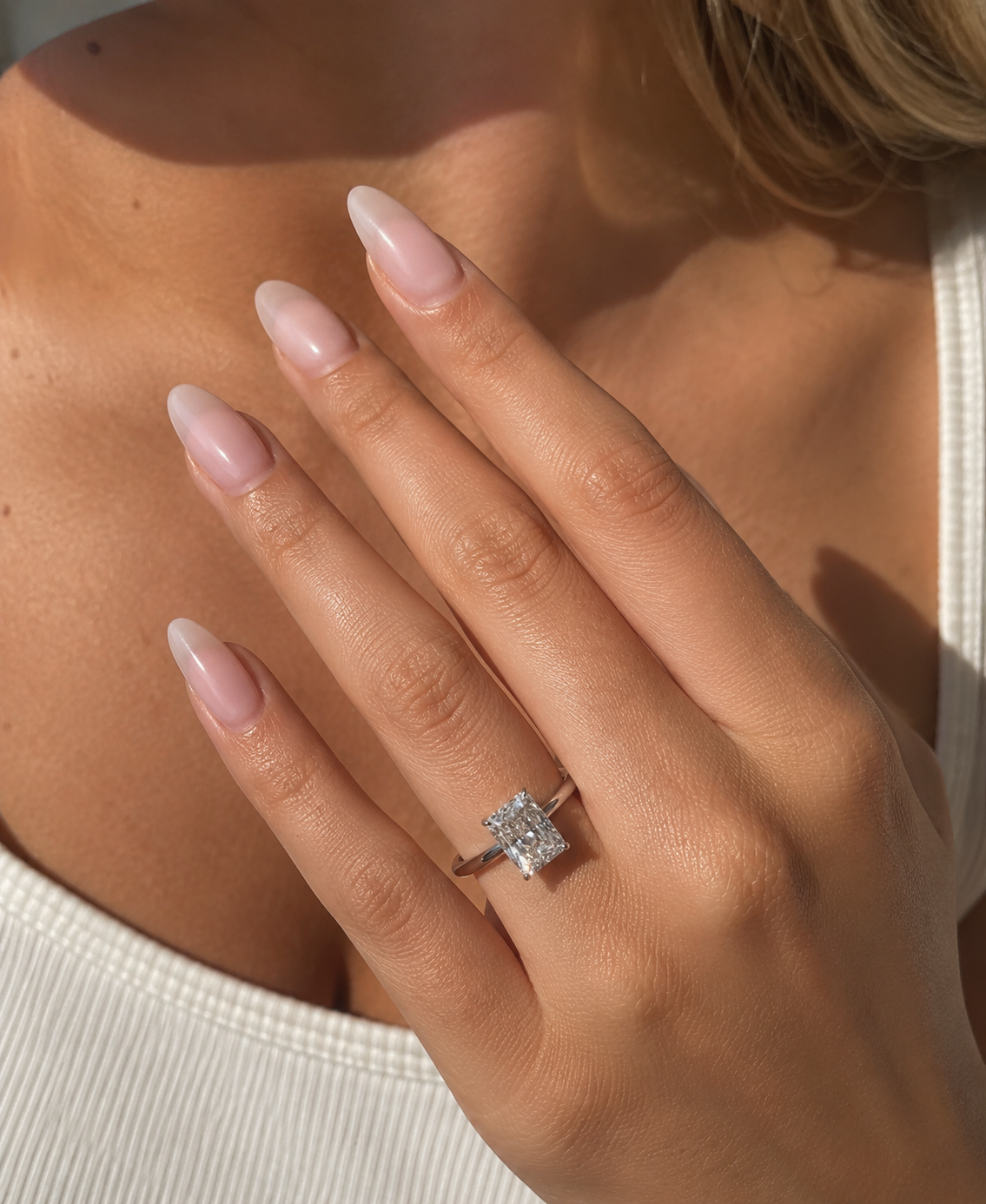 2.94 carat radiant cut lab-grown diamond solitaire engagement ring on woman finger.