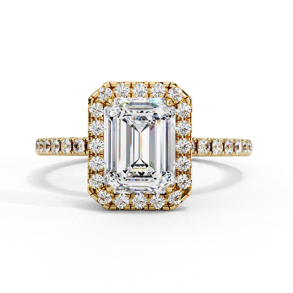 Gold ring with emerald-cut diamond and smaller diamonds on a white background