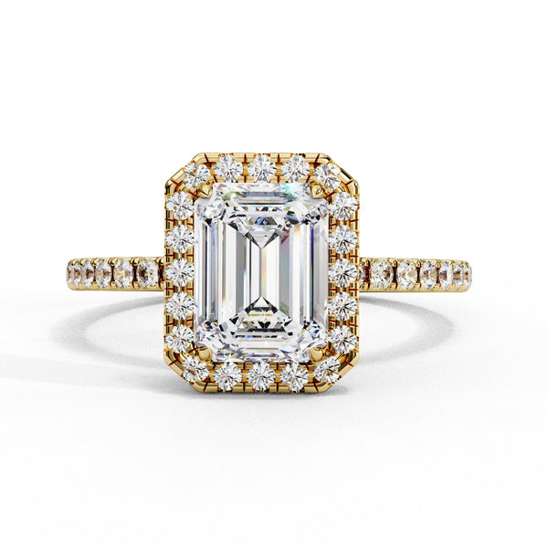 Gold ring with emerald-cut diamond and smaller diamonds on a white background