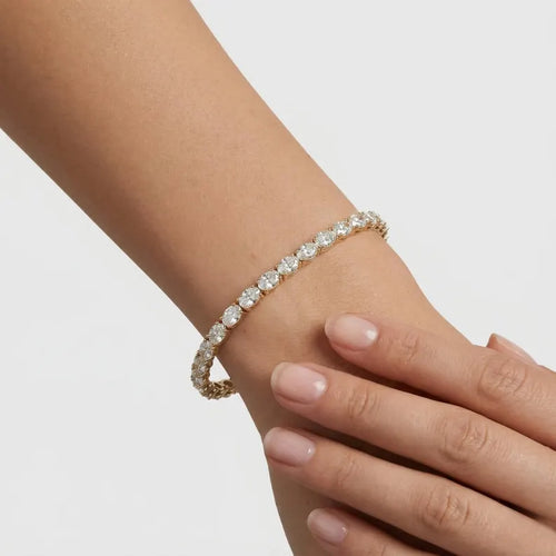 Diamond bracelet on a person's wrist against a plain background