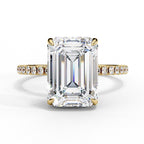 Diamond ring with emerald-cut center stone and gold band on a white background