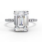 Diamond ring with emerald-cut center stone on a white background