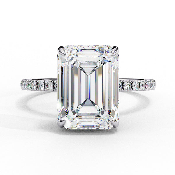 Diamond ring with emerald-cut center stone on a white background