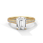 Gold ring with a large diamond and smaller diamonds on the band against a white background